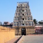 A distant view of a stunning temple with multiple upper layers in vibrant colours.