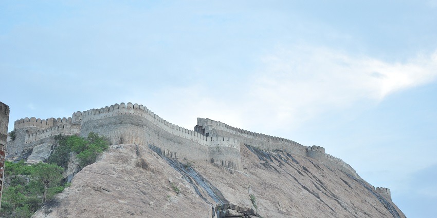 Namakkal Fort on top of a hill featuring stone walls and blue sky on the backdrop.