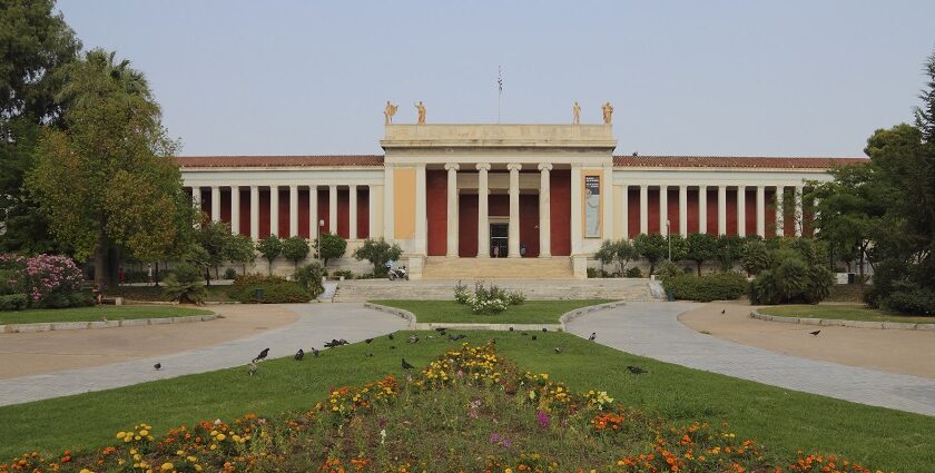 The entrance of the National Archaeological Museum with stairs, flowers and trees.