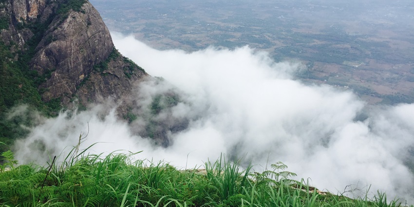 A serene view of Nelliyampathy featuring majestic peaks and lush green vegetation.