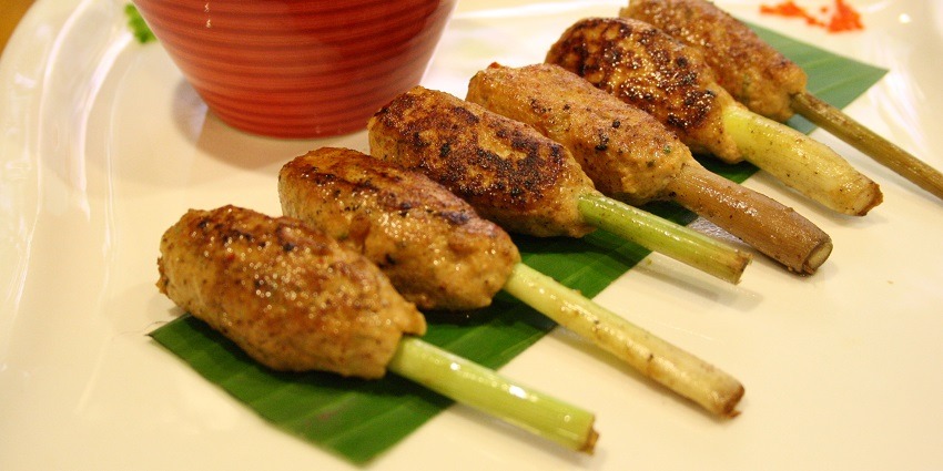 A side view of several pieces of chicken kebabs lemon flavoured are placed on a plate