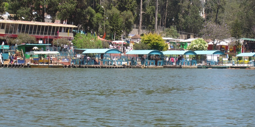 Scenic view of Ooty Lake surrounded by greenery and peaceful waters under a cloudy sky