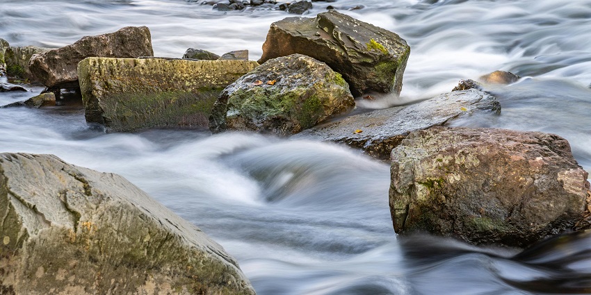 A photograph of a waterfall tumbling over a surrounding rocky landscape in the daytime