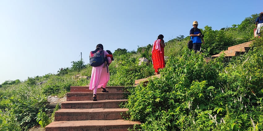 Vaibhavagiri Hill in Rajgir with rocky slopes and a pathway with tourists going up.