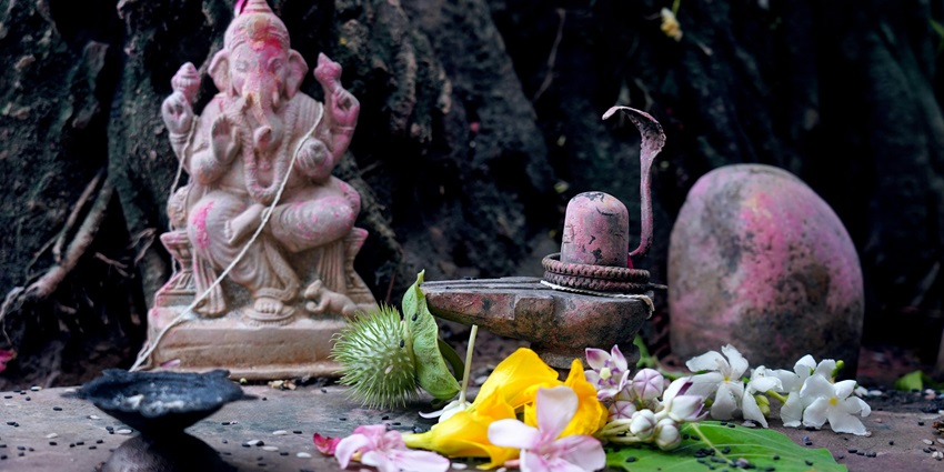 Lord Shiva and Lord Ganesha idols with flowers and a lamp placed in front of them