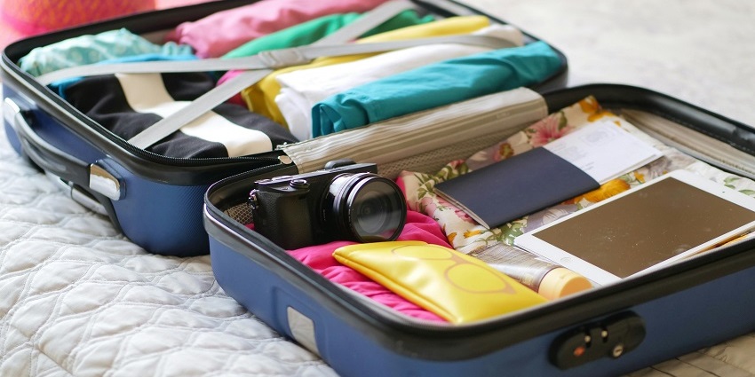 Open suitcase packed with clothes and assorted items, ready for travel or a trip