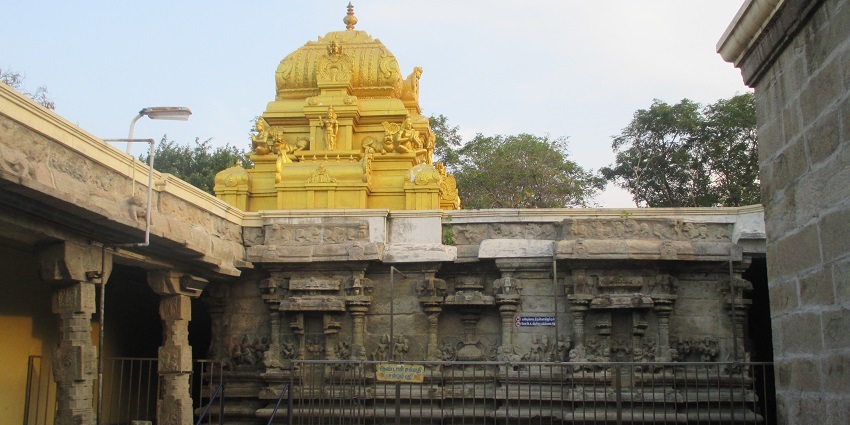 A picture of a temple gopuram visible from the inside of the temple courtyard