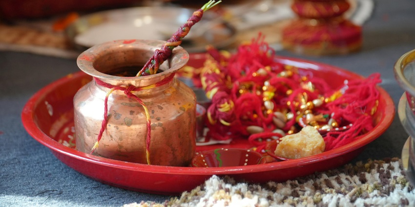 Pooja thali with offerings, including flowers, diya, and incense sticks, arranged for a Hindu ritual