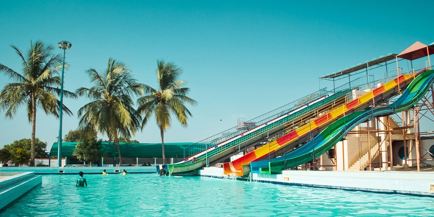 A water slide in the middle of a swimming pool, with clear blue water and a sunny atmosphere