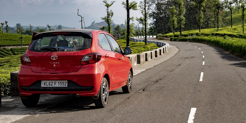 A red Tata Tiago car parked along a scenic road in Valparai, surrounded by greenery
Viewers of this file can see comments and suggestions