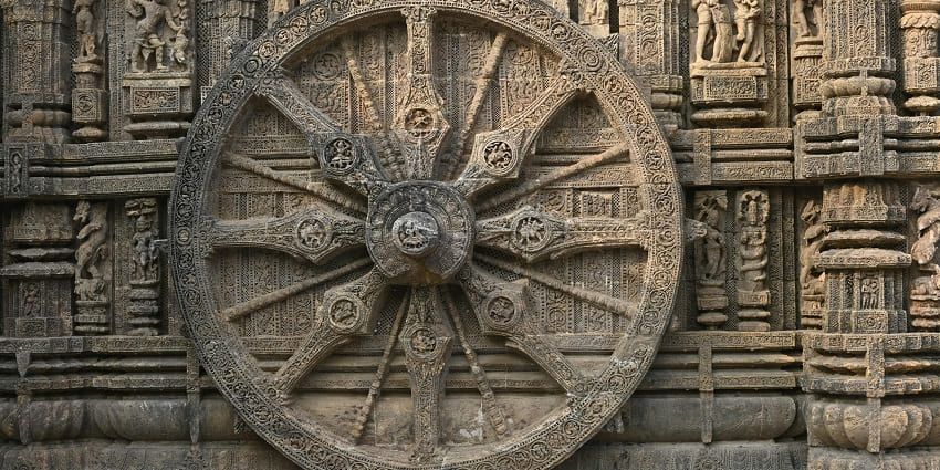 Close-up of a rustic brown wooden carriage wheel with detailed spokes and texture.