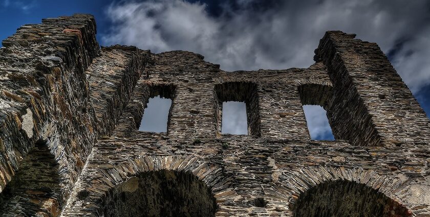 An image of a ruined stone wall with arched windows at a Fort which resembles the Padmadurg fort in Maharashtra.