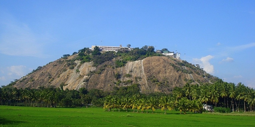 A picture of Palani Hills, with rolling green landscapes and temple views.