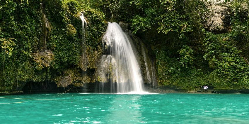 A waterfall flowing over rocks into a pool, a popular destination near Thalaiyar waterfalls.