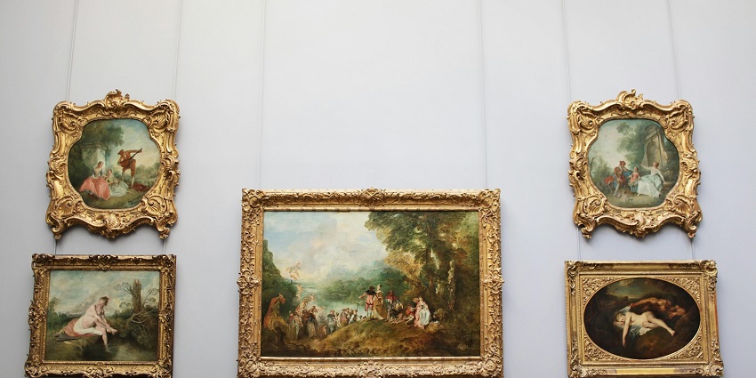 An image of a woman standing in front of a display of paintings in the Panchal Museum.