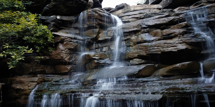 A serene view of the Panchalinga Waterfall cascading from the cliffs of the region.