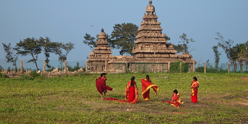 One of the famous temples of India, with greenery around and five women in red sarees.