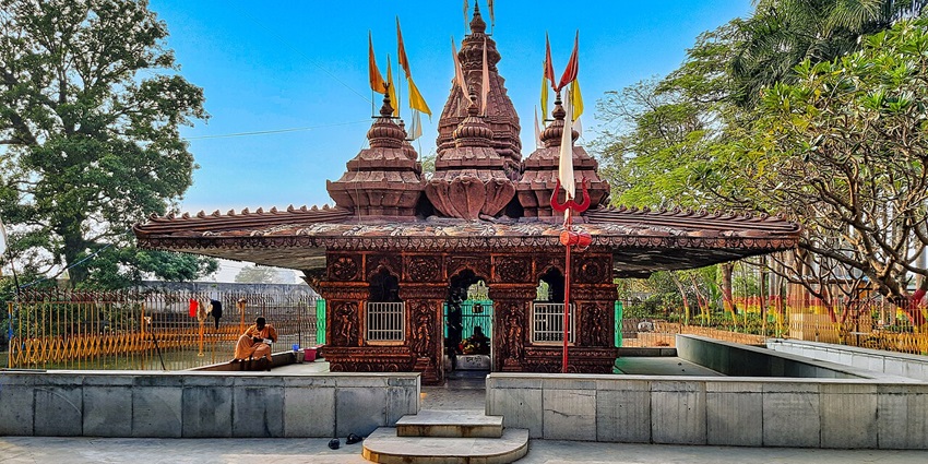 A majestic view of the Temple showcasing its intricate architecture set against a clear blue sky and surrounded by lush greenery.