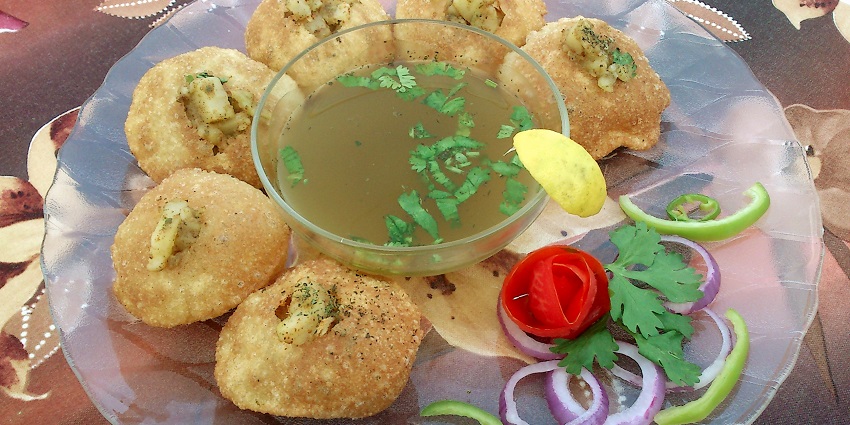 A vibrant street food scene in Lucknow with golgappas served