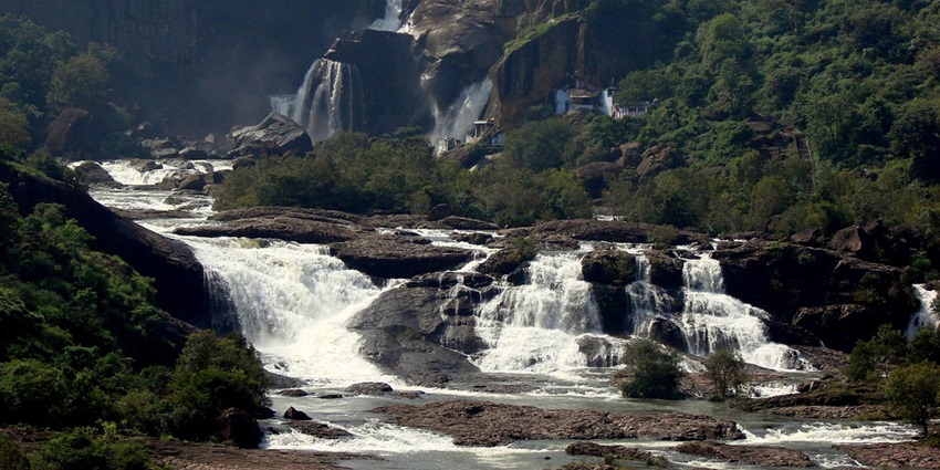 Waterfall flowing down into the Thamirabarani River surrounded by dense greenery