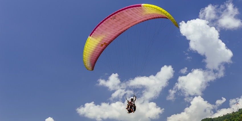 Traveller soaring high with paragliding adventures in Gangtok and enjoying the view
