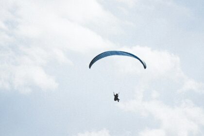 Thrilling paragliding in Uttarakhand amidst stunning snow-capped mountain landscapes.