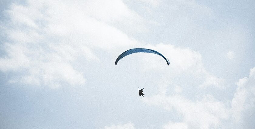 Thrilling paragliding in Uttarakhand amidst stunning snow-capped mountain landscapes.