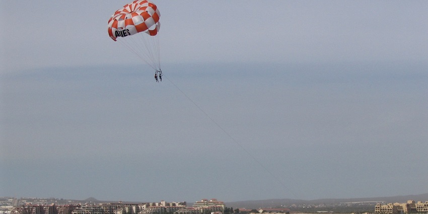 A picture of a person parasailing, which is at one of the top water sports in Kashid Beach.