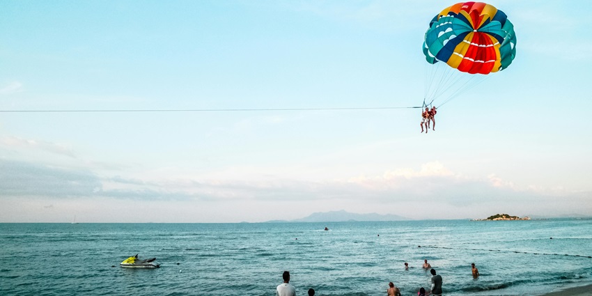 A breathtaking picture of parasailing over Kihim Beach with stunning coastal views below.