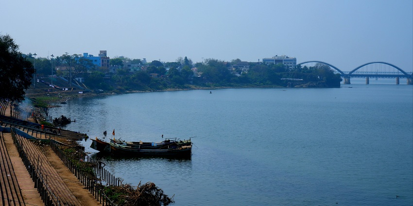 Men taking a dip in the holy Indian river Kaveri performing sacred morning rituals.