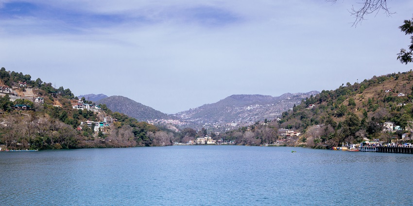 A picture of a lake with blue waters and mountain in the background