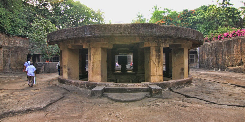 A picture of an ancient temple with worshippers praying around