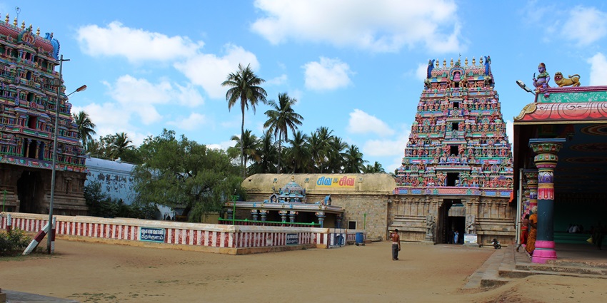 Outside area of Patteswaram Temple with vibrant temple structures in Dravidian style.
