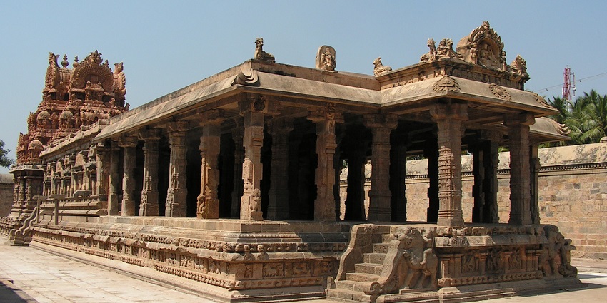 A view of the intricate architecture of Periyanayaki Amman Temple under a clear blue sky.