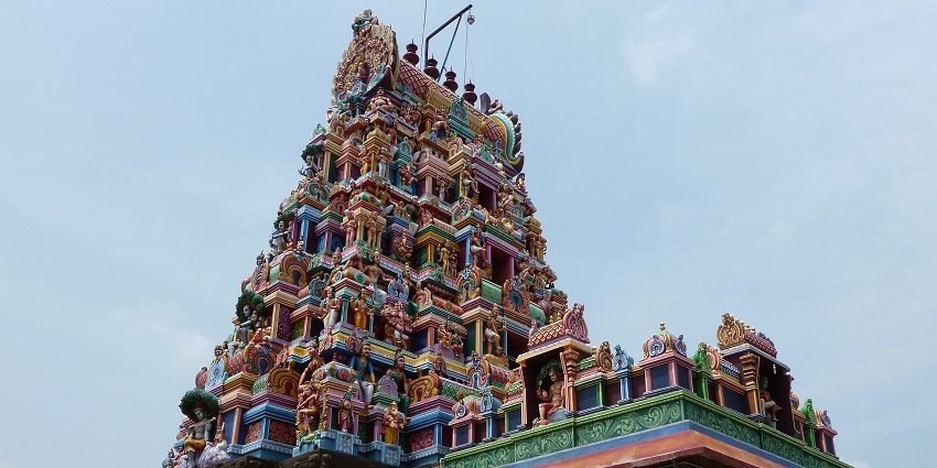 An image of the tall entrance tower of Perur Patteshwarar Temple against a wide blue sky.