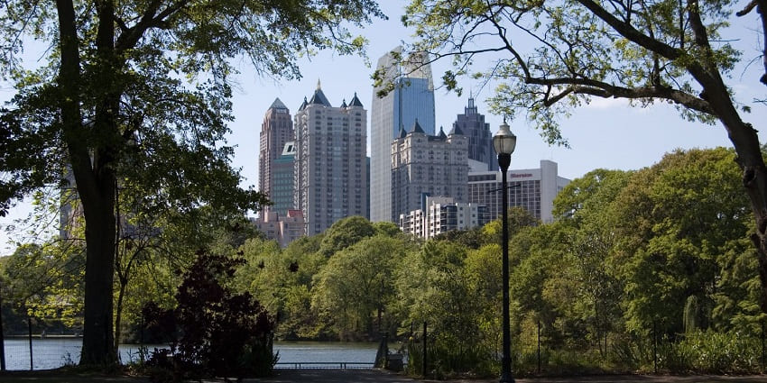 View of mid-town Atlanta from Piedmont Park where you can see trees, bushes and tall buildings