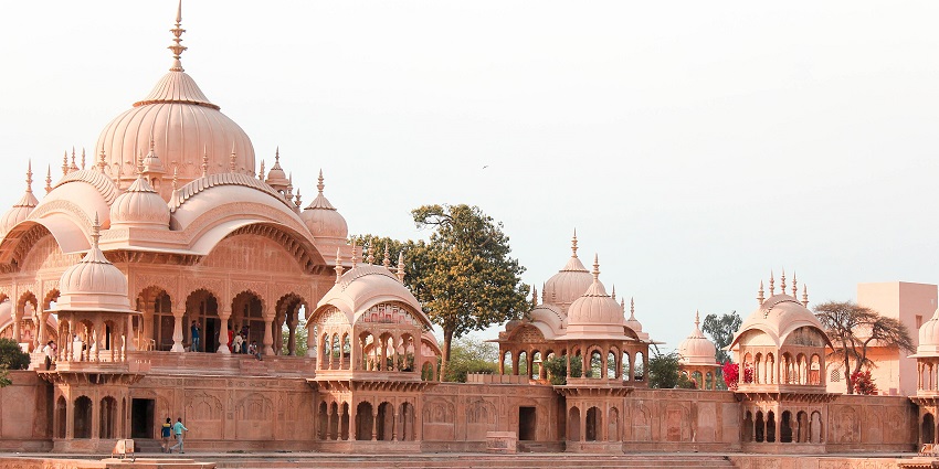 A picture of a serene water body in front of a traditionally built monument