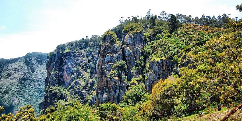 A panoramic image of Pillar Rocks near Kodaikanal features stunning rock formations.