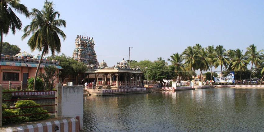 Gopuram of the Pillayarpatti Vinayagar Temple is shown with a large stretch of water ahead