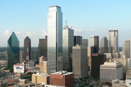 Tall skyscrapers of Dallas with glass buildings and an advertisement banner on the road