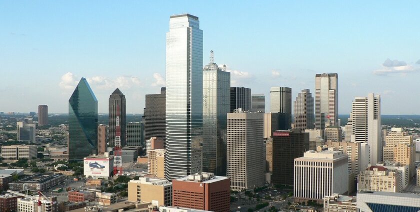 Tall skyscrapers of Dallas with glass buildings and an advertisement banner on the road