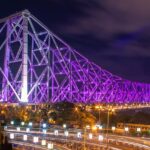 A picture of the famous Howrah Bridge, lit up in beautiful colourful lights during nighttime