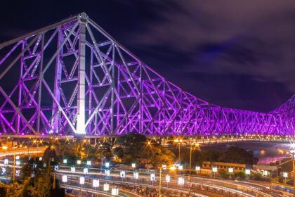 A picture of the famous Howrah Bridge, lit up in beautiful colourful lights during nighttime