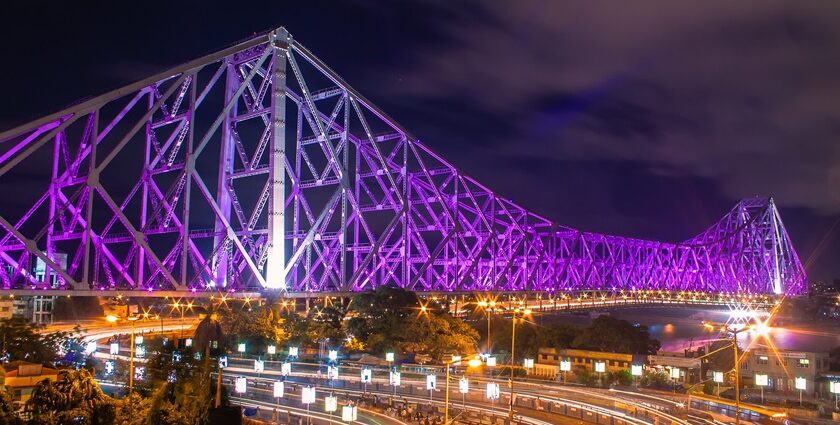 A picture of the famous Howrah Bridge, lit up in beautiful colourful lights during nighttime