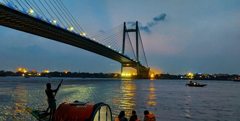 A serene capture of people riding a boat on a body of water during the evening in Kolkata.