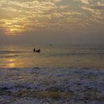 An image showing a scenic view from University Beach in Pondicherry, showcasing calm waves and sand.