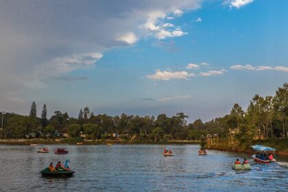 A panoramic view of a serene lake in Salem showcasing urban structures and greenery.