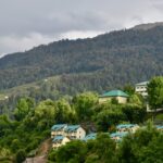 Places to visit in Uttarakhand in July offer a temple surrounded by mountains