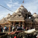 A picture of a temple in Rohtak with a crowd of devotees standing in queue outside