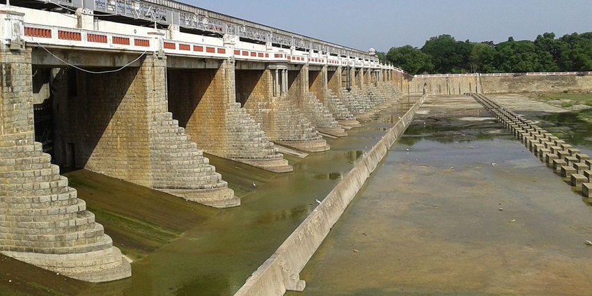 The massive stone and concrete structure of Poondi Dam, Tamil Nadu surrounded by greenery.